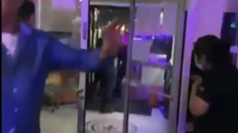 Female guard beats up people inside store in Asia.