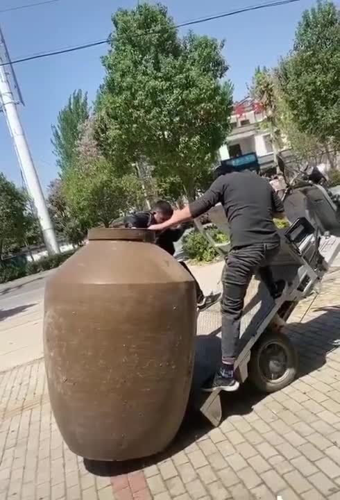 Two guys trying to move a giant vase...wait for it.