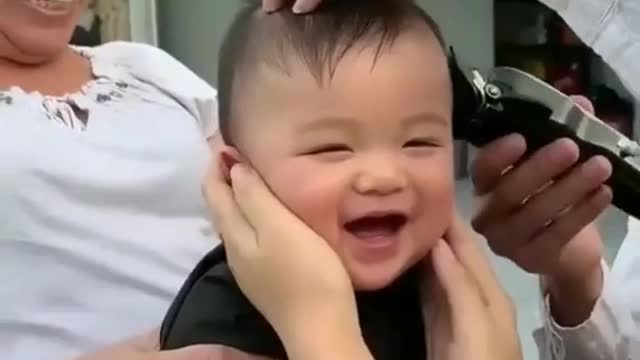 Cute baby laughing on is hair cut