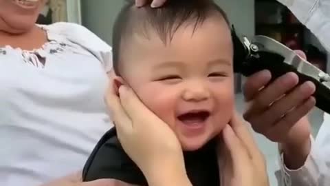 Cute baby laughing on is hair cut