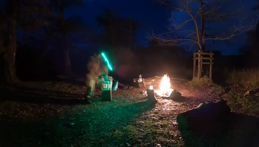 Chopping firewood by the campfire. Night lapse