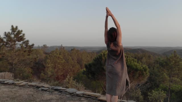 Person Doing Meditation Exercises On The Mountain Side