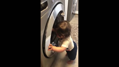 Baby finds washing machine so fascinating !