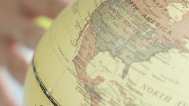 a-person-sticking-a-small-house-on-a-world-map