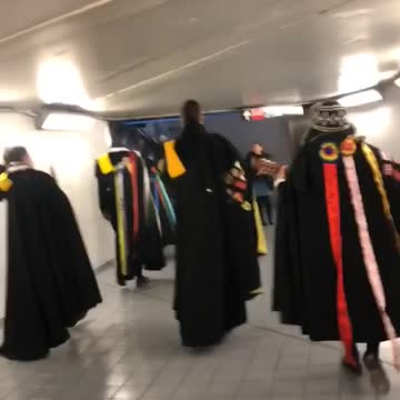 People dressed in medieval clothing walk through subway station