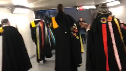 People dressed in medieval clothing walk through subway station