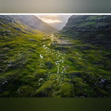 A river running through a lush green valley
