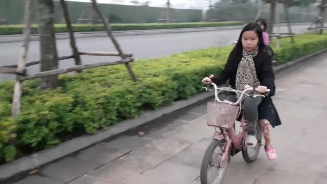 Little girls riding bicycles in part