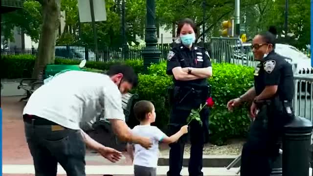 FATHER AND SON GIVE ROSES TO OFFICERS