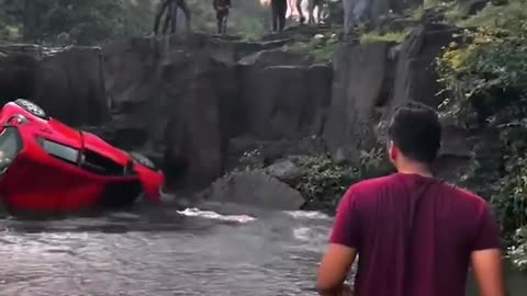 Parked car rolls over waterfall.