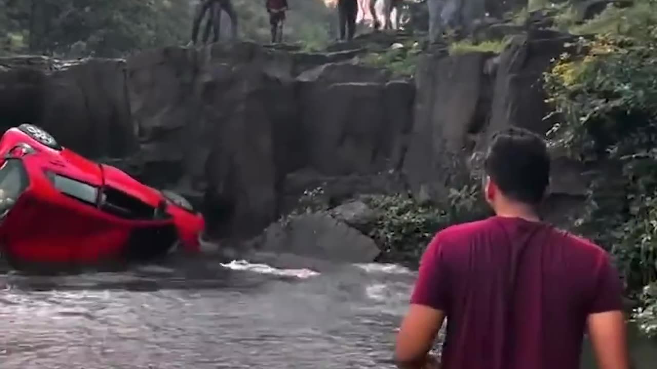 Parked car rolls over waterfall.