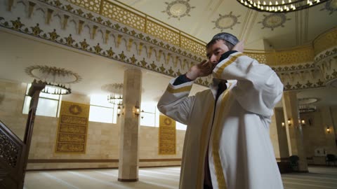 A MAN PRAYING IN A MOSQUE