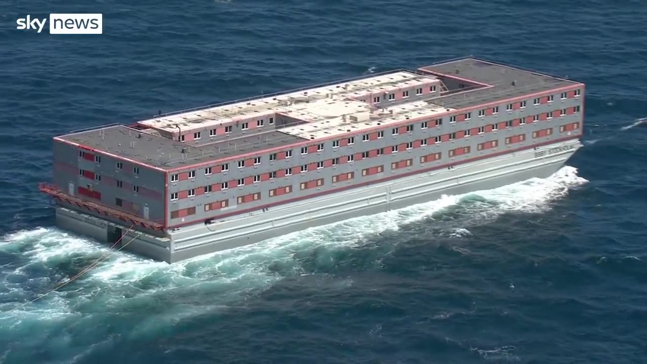 Bibby Stockholm barge en route to Portland Harbour, beside the Isle of Portland, Dorset, England.