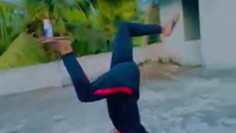 Guy Balances Can on Foot While Doing Handstand