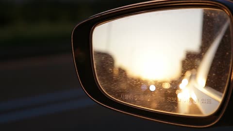 the sunlight reflected in the car's rearview mirror