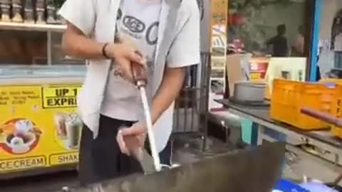 Asian Boy cooking noodles on street