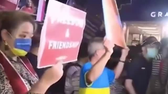 Taiwan residents meet Nancy Pelosi at the airport wearing masks in the Ukrainian colors