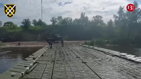 Ukrainian army prepares for attack by moving heavy equipment across river with pontoon bridges