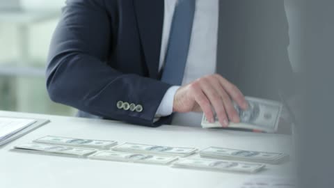 A Man Counting Cash Money And Put It Into Record