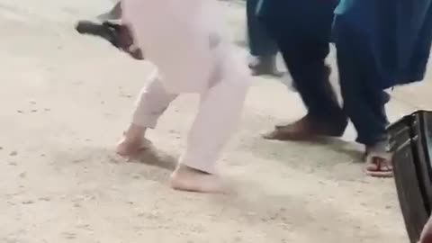 A Pakistani little boy drunken dance with pistol and guns