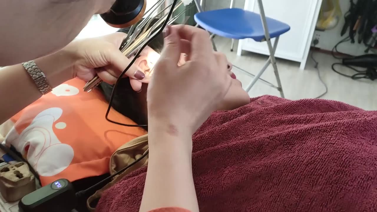 Relaxing female, shaving her face, getting a Vietnamese woman's earwax