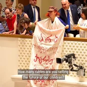 An activist throws Russian rubles upon Georgian Dream MPs in Georgian Parliament