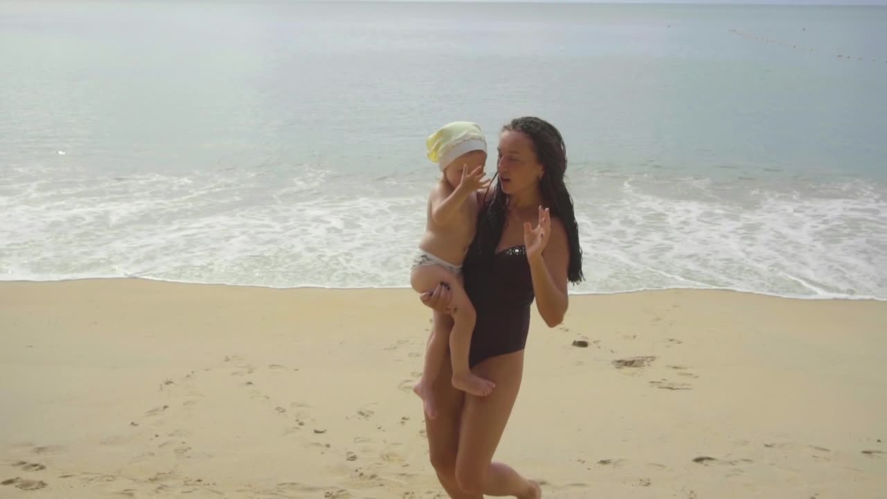 Mom and daughter dancing in the beach