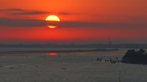 Italy cloud streak over rising sun at the entrance to Venice lagoon