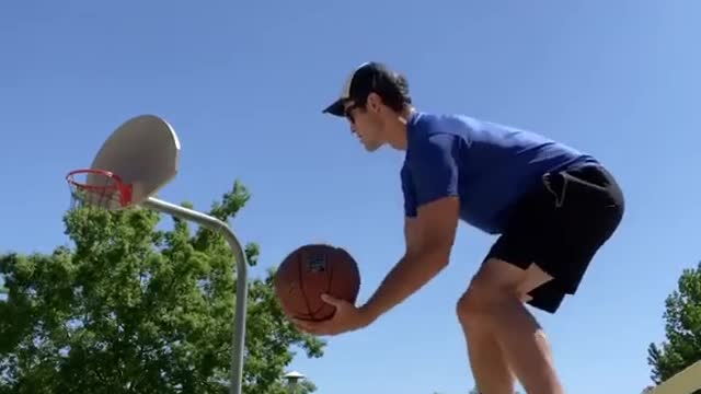 Guy Balances Himself Over Slackline While Throwing Two Basketballs After Dribbling Them