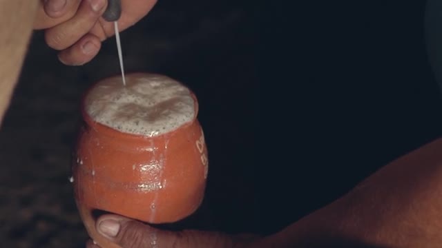 Traditionally cow milking by hand to a pot.