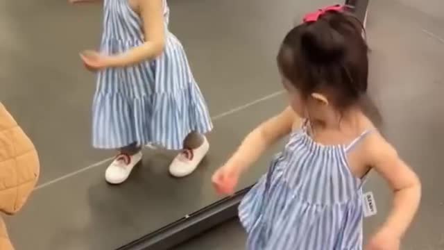 The cute girl danced astir, saw the mirror and started dancing