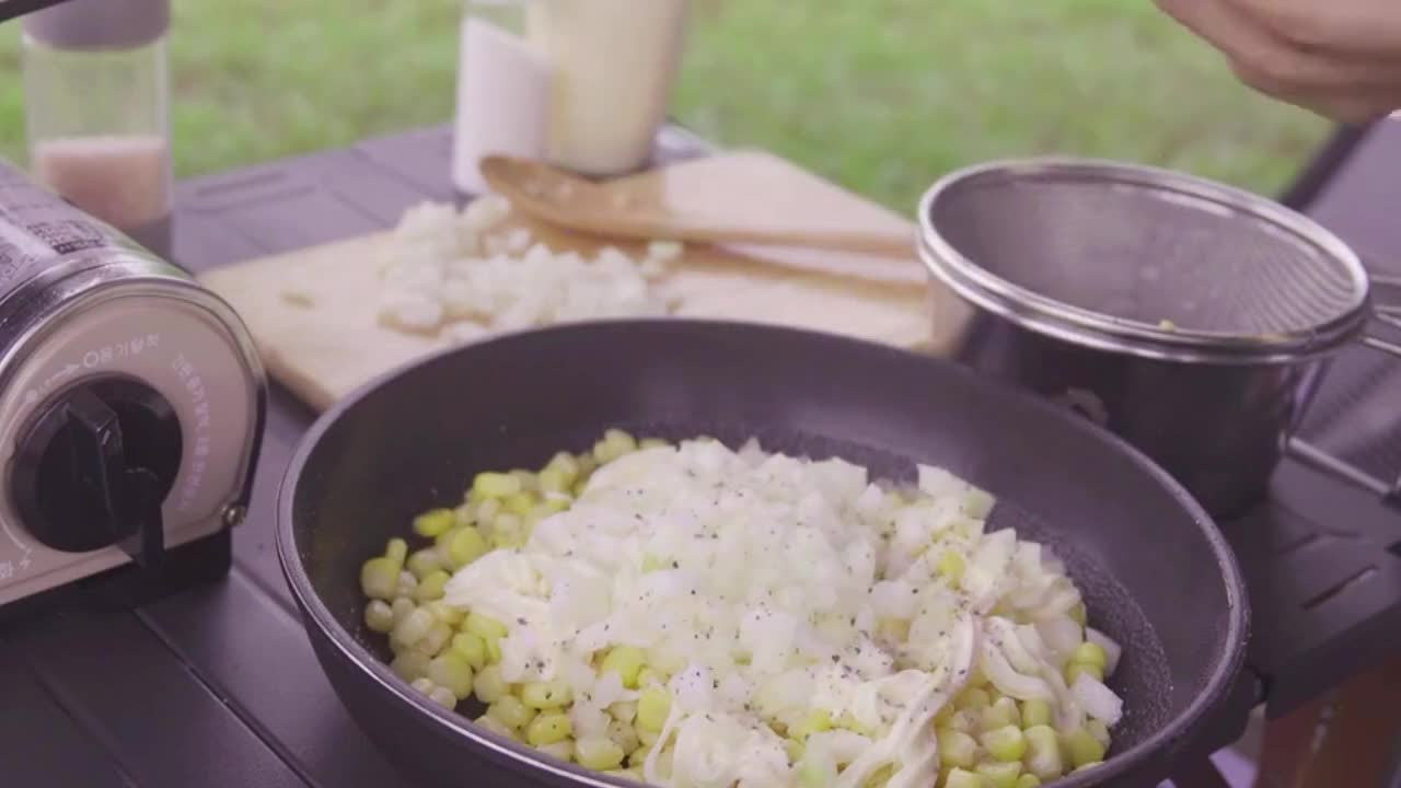 A man cooks outdoors in the rain