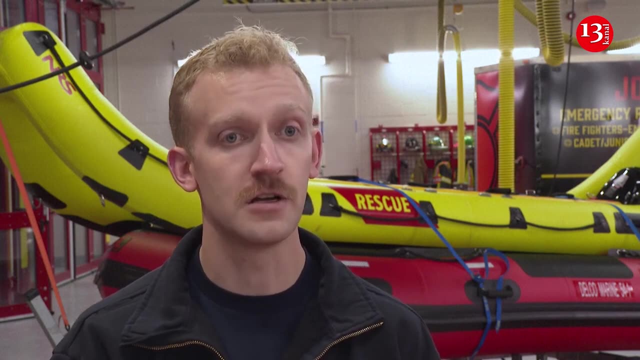 Firefighters rescue a man from rushing flood water