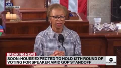 Who is feeding her lines at the podium?