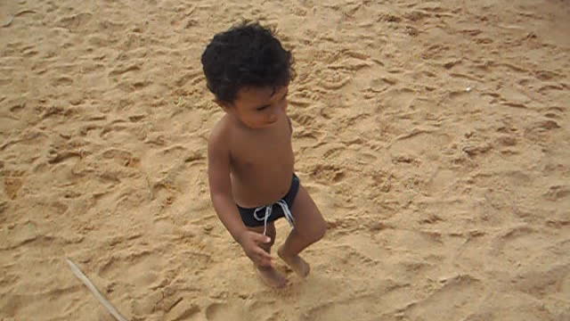 Baby playing ball on the beach