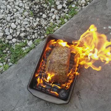 Cooking beef roast on pan off of grill on floor