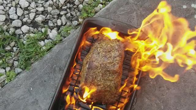 Cooking beef roast on pan off of grill on floor