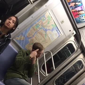 Man in green jacket twirling hair