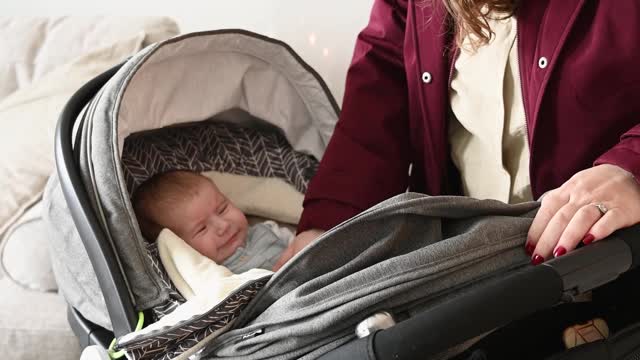 mother-comforting-baby-in-stroller