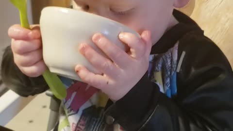 Cute baby drinks soup