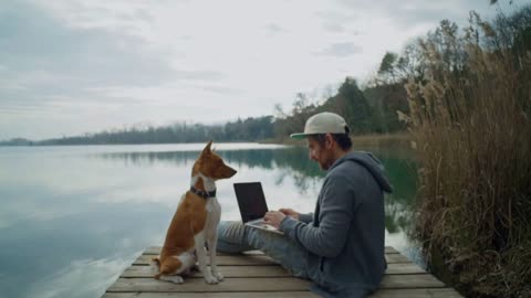 Serious and funny cute young man with laptop works on important project