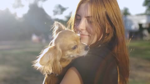 Young beautiful woman in the park with her funny long-haired chihuahua dog