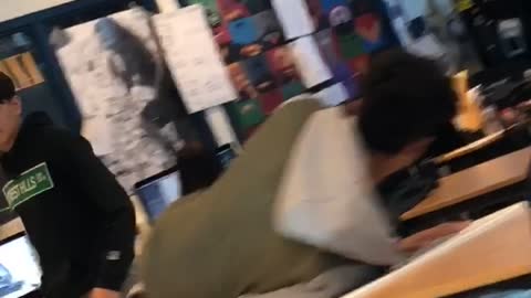 Guy jumps on table in class and breaks it
