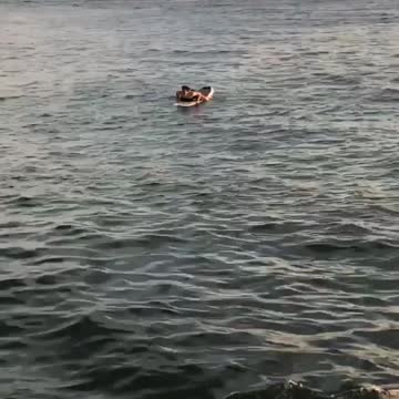 Guy swimming on surfboard in water