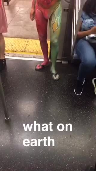 What on earth man in green and red body paint boards train