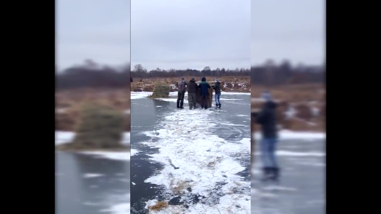 Extreme cold forces villagers to move hay bales across frozen river