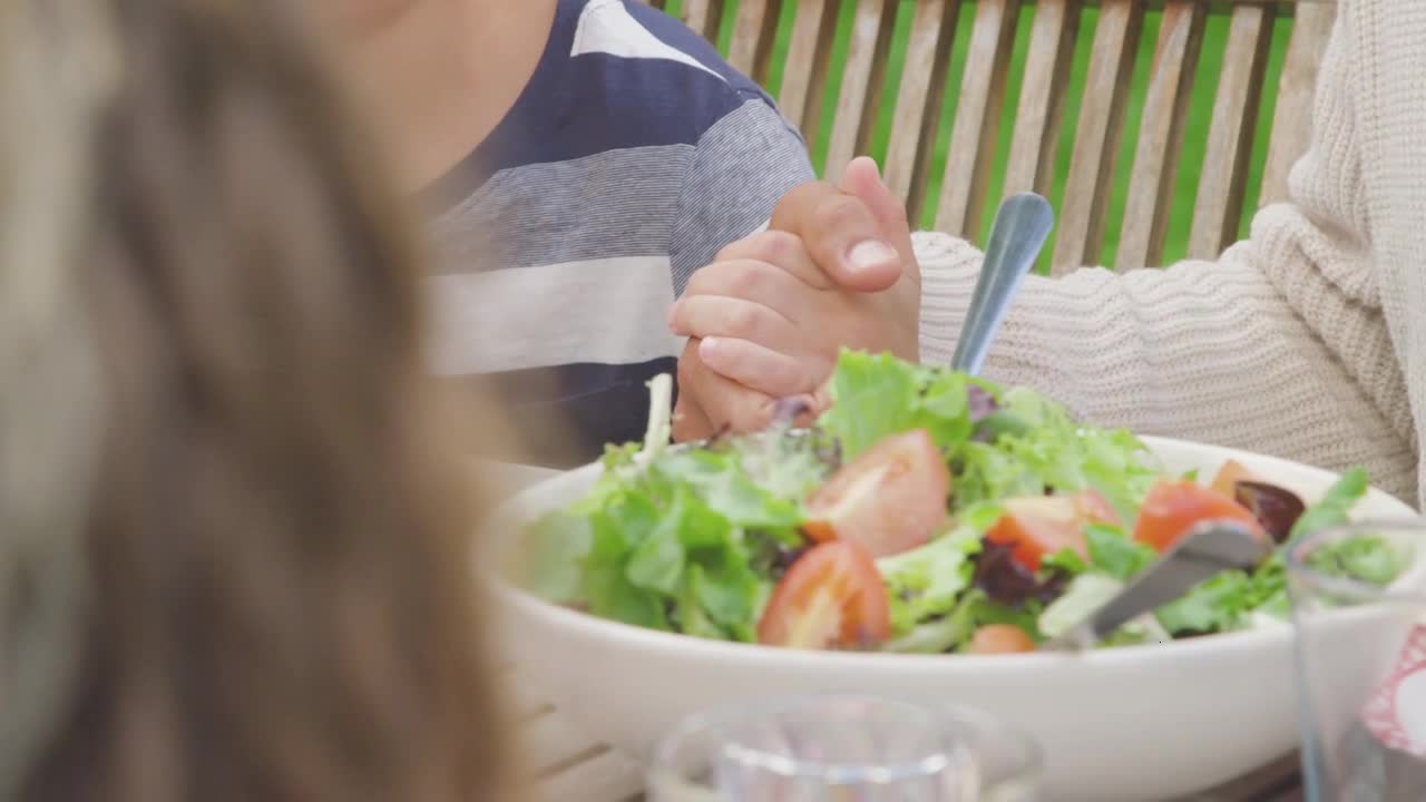 Close Up Shot of Young Boy Holding Father's Hand During Grace