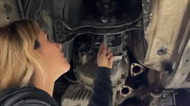 A repairman replaces the automobile clutch with new parts to repair the car.