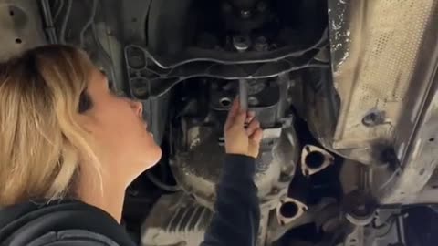 A repairman replaces the automobile clutch with new parts to repair the car.