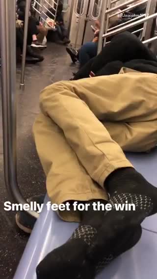 Guy puts his smelly feet out on subway seat